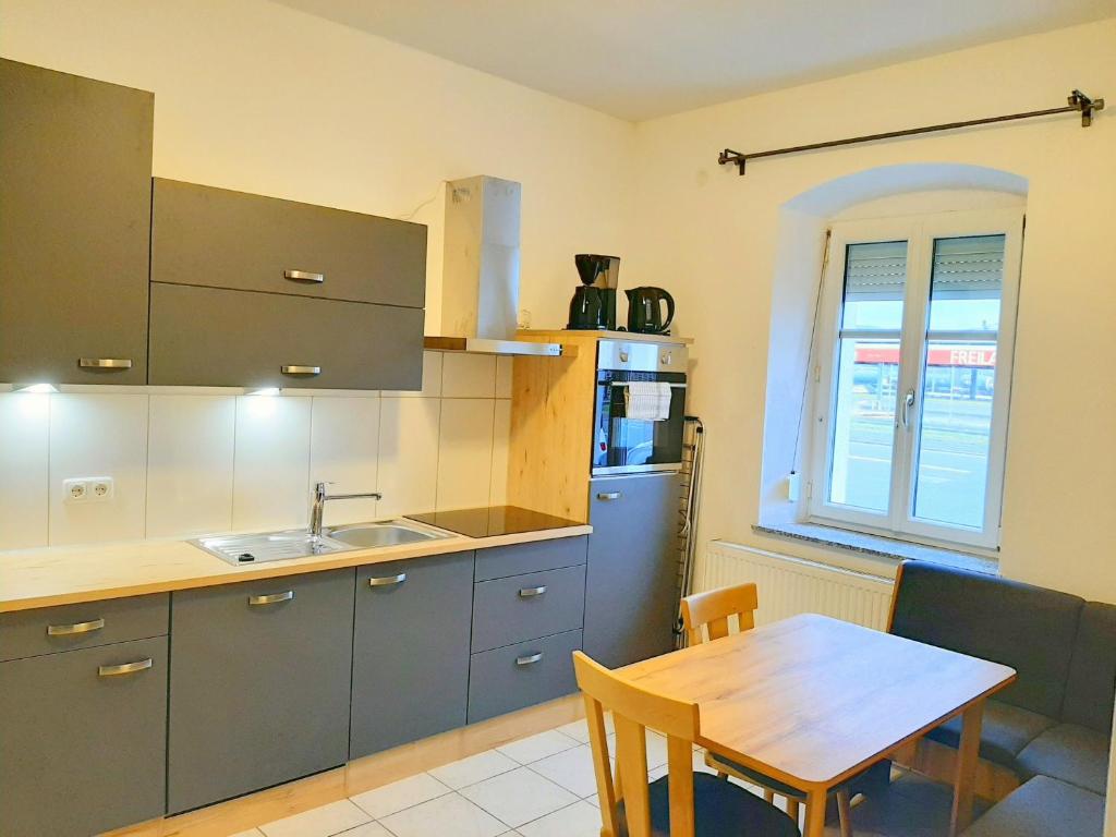 eine Küche mit einem Holztisch und einem Tisch sowie ein Esszimmer in der Unterkunft Apartments SteelCity in Linz