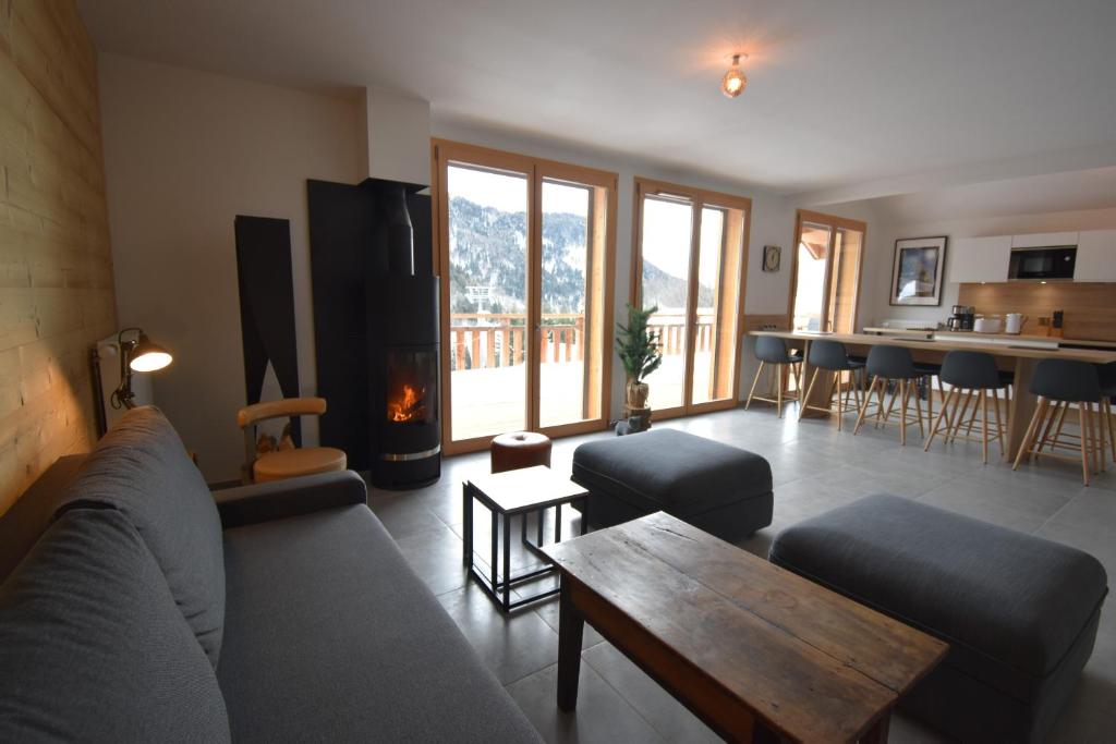 a living room with a couch and a fireplace at VAUJANYLOCATIONS - Le Chalet d Antoine et Mary in Vaujany