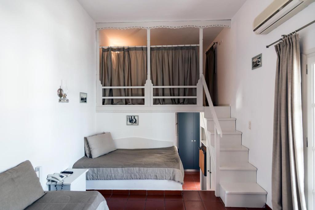 a bedroom with a bed and a stair case at DIMITRIOS in Skiros