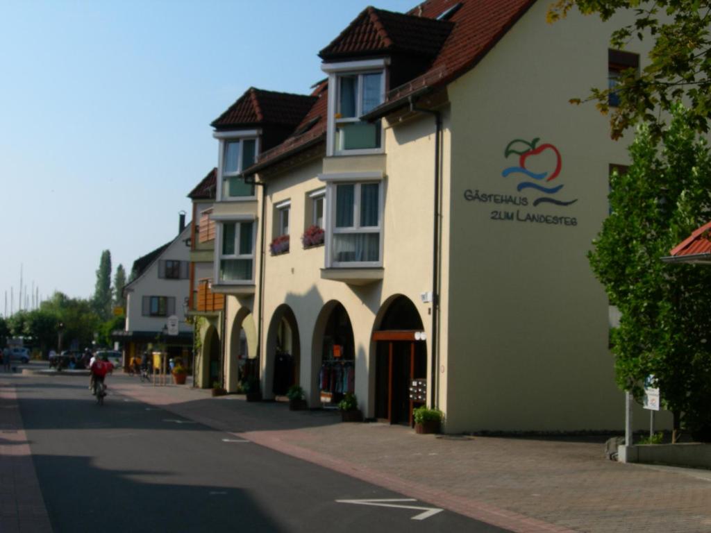 un bâtiment situé sur le côté d'une rue dans l'établissement Gästehaus zum Landesteg, à Immenstaad am Bodensee