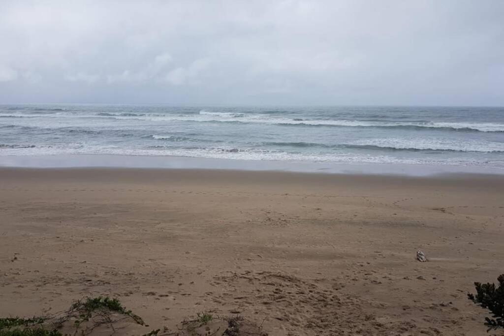 a sandy beach with the ocean in the background at Direct Access to the Beach in Port Edward