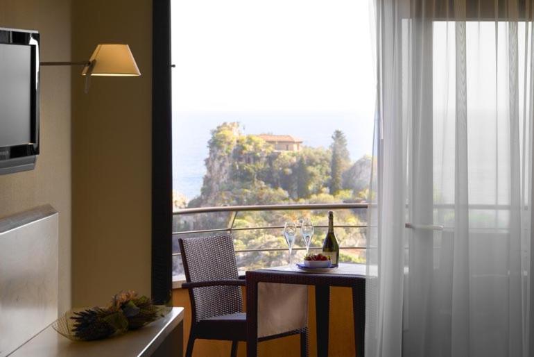 a kitchen with a table and a window with a view at Taormina Panoramic Hotel in Taormina