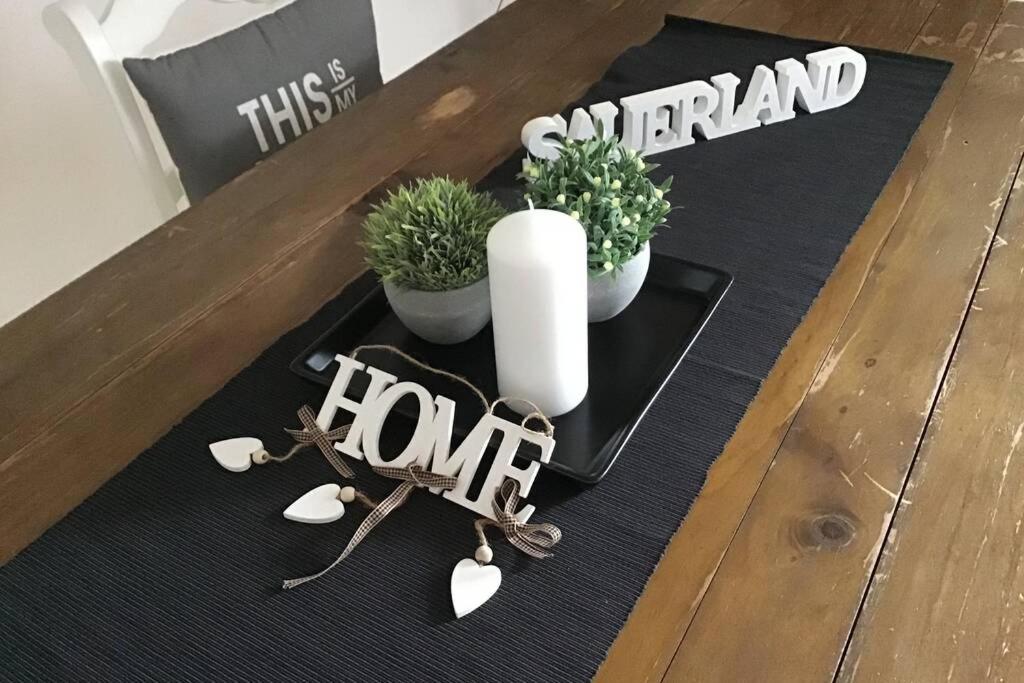 einen Tisch mit Pflanzen und ein Schild, auf dem zu Hause steht in der Unterkunft Ferienwohnung Sauerland in Attendorn