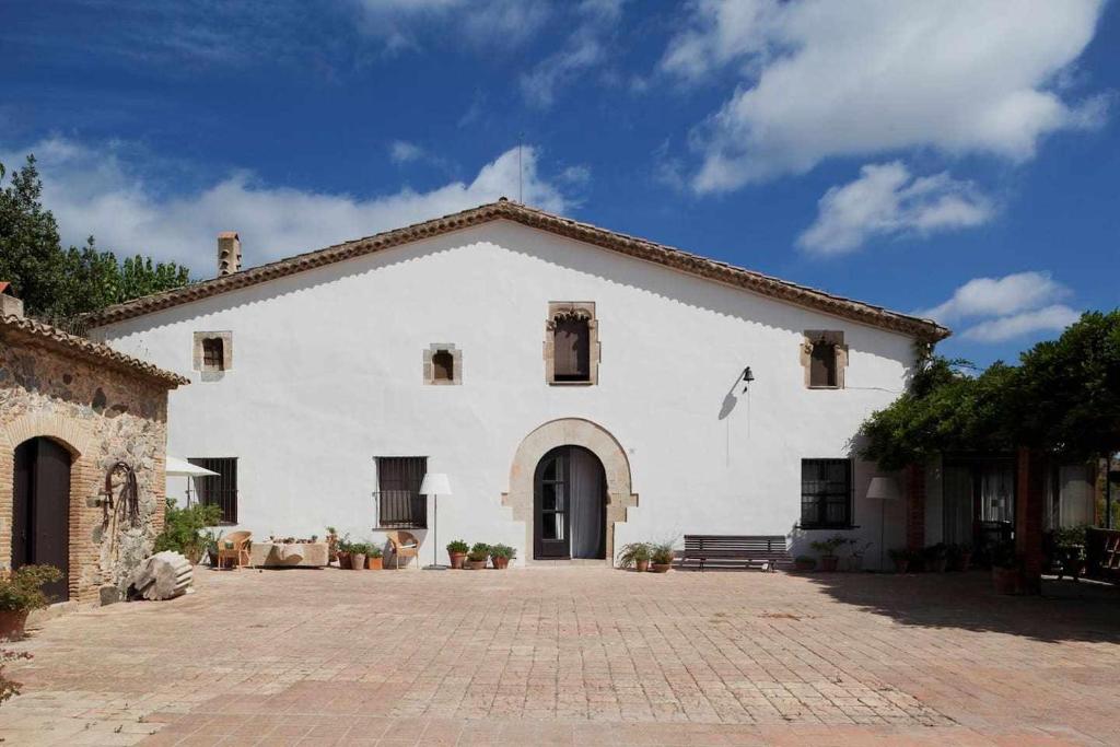a large white building with a brick driveway at Ca lAndreu Ecoturisme in Tiana