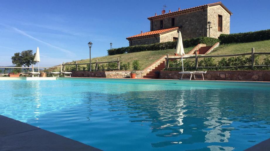 une grande piscine en face d'un bâtiment dans l'établissement Il Poggio Della Pieve Apartments, à Santa Luce