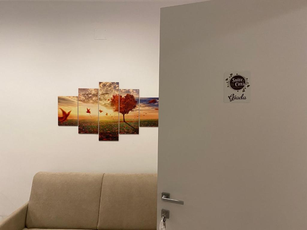 une chambre avec trois peintures sur le mur dans l'établissement Suite in Città residence, à Isernia