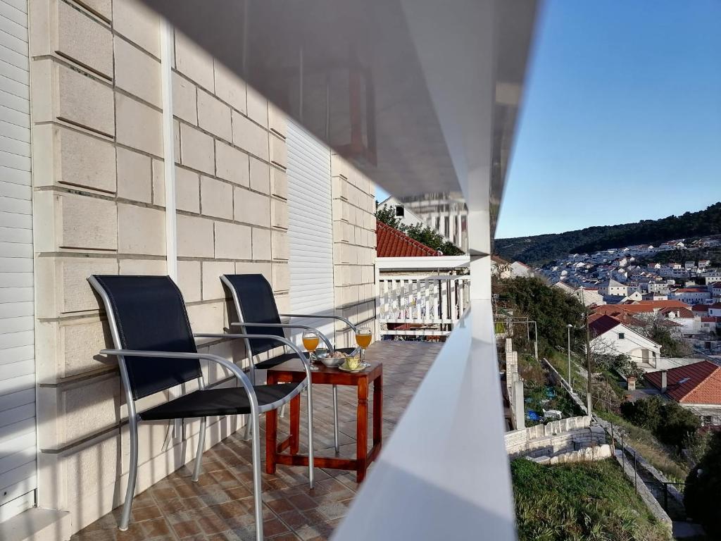 a balcony with two chairs and a table on a building at Apartment Kika *** in Pučišća