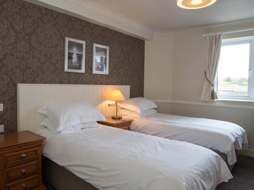 a hotel room with two beds and a window at Botany Bay Hotel in Broadstairs