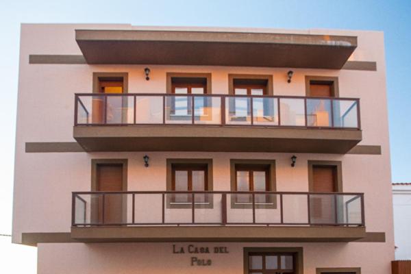 een hoog gebouw met een balkon erboven bij La Casa Del Polo- Alltarifa in Tarifa