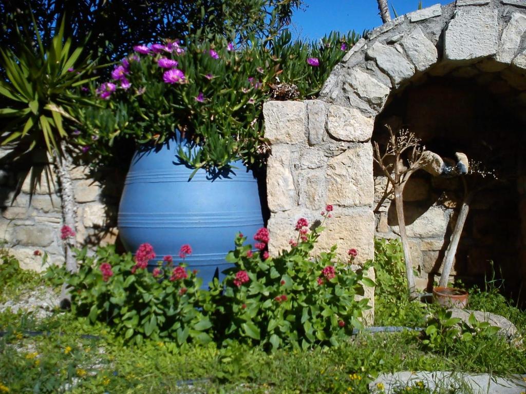 a large blue pot with flowers in a garden at Aloni in Kamilari