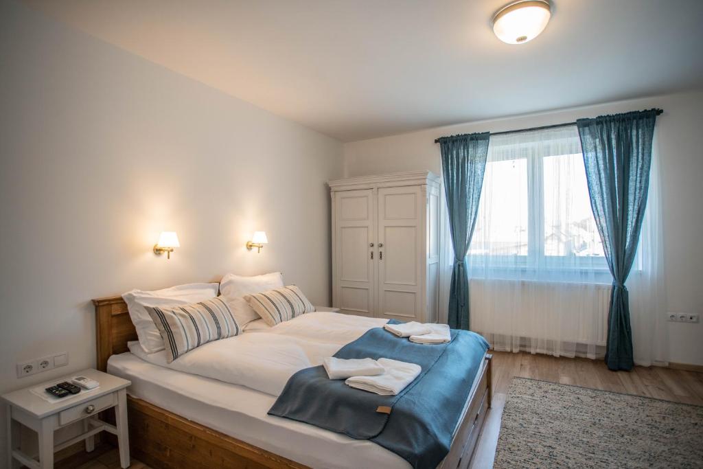 um quarto com uma cama grande com duas toalhas em Tündérliget Panzió em Egerszalók