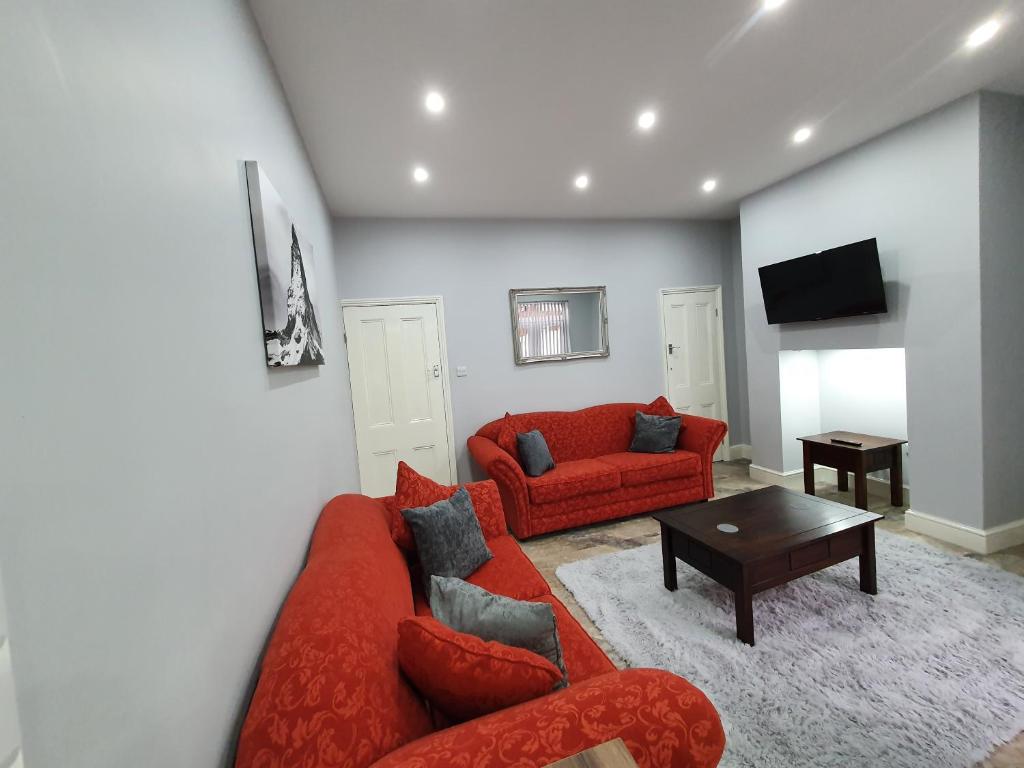 a living room with a red couch and a table at The Shed in Darlington