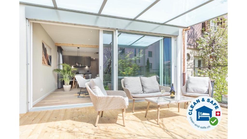 a glass extension of a house with chairs and a table at Eiche in Interlaken