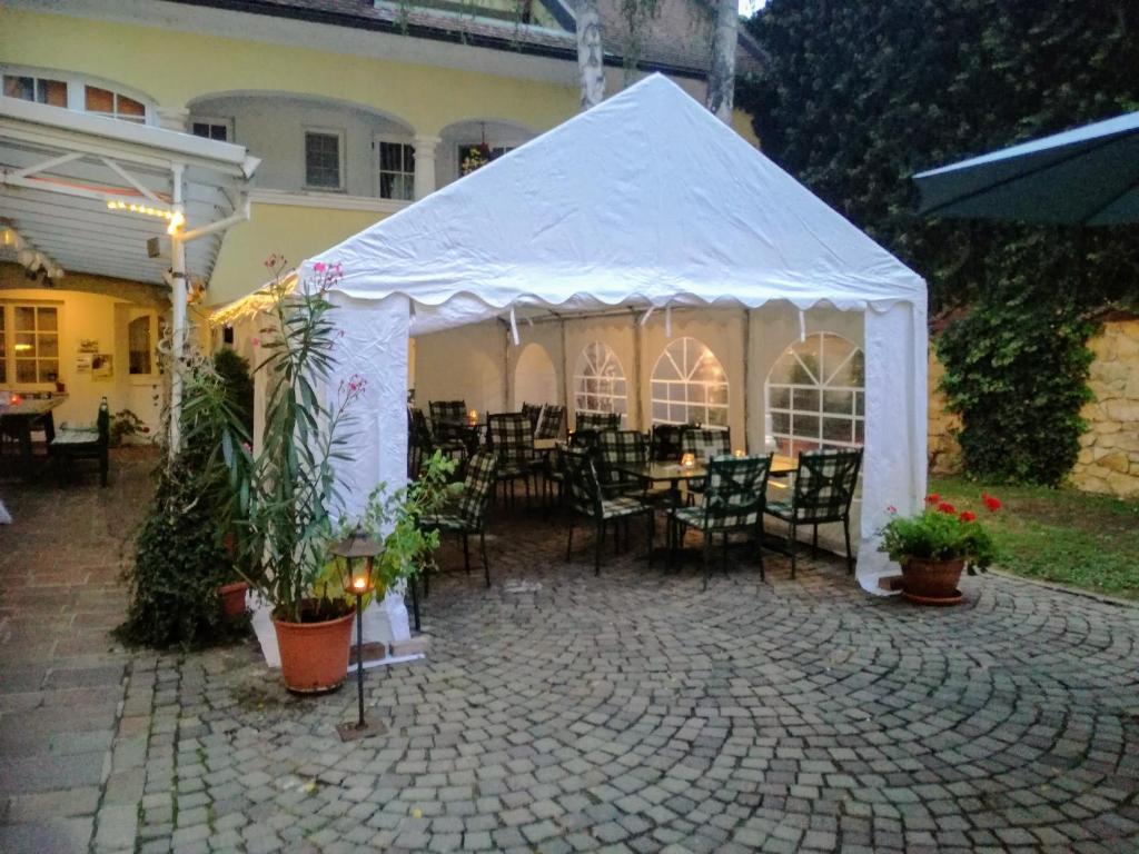 a white tent with chairs and tables in front of a house at Rathausstüberl in Bad Radkersburg
