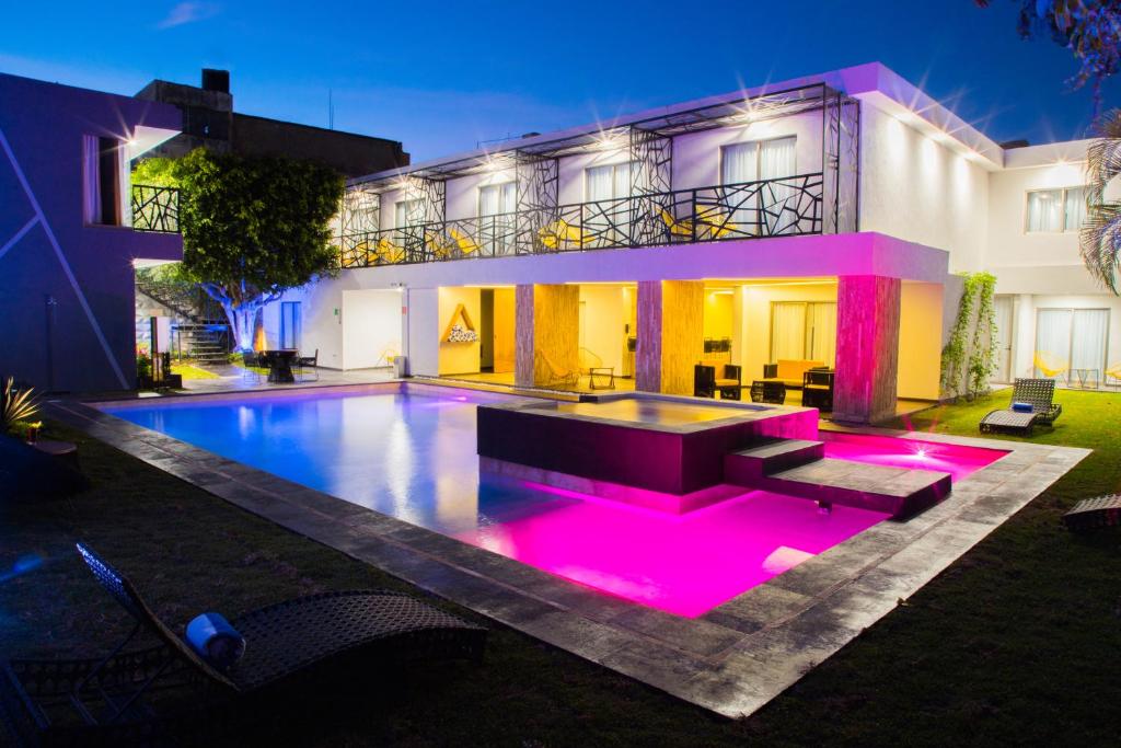 a house with a swimming pool with purple lights at Ramë Hotel Boutique in Guadalajara