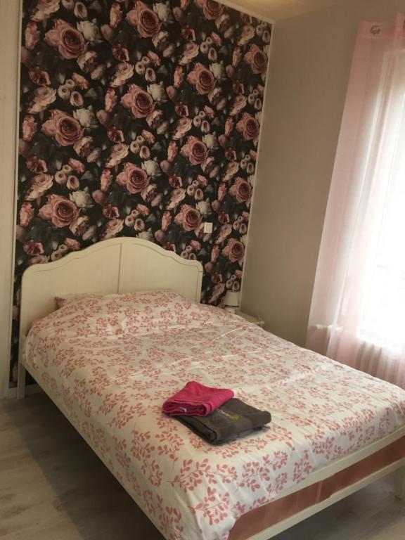 1 dormitorio con 1 cama con pared de flores en La Vie est Belle, en Abbeville