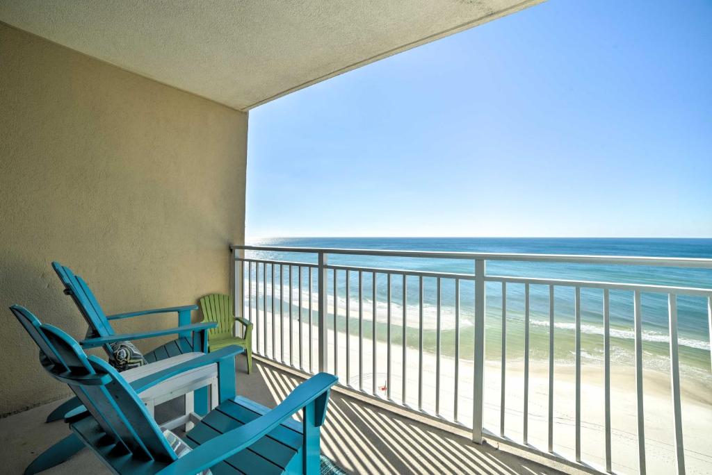2 sillas azules en un balcón con vistas a la playa en Spectacular Oceanfront Emerald Beach Resort Condo, en Panama City Beach