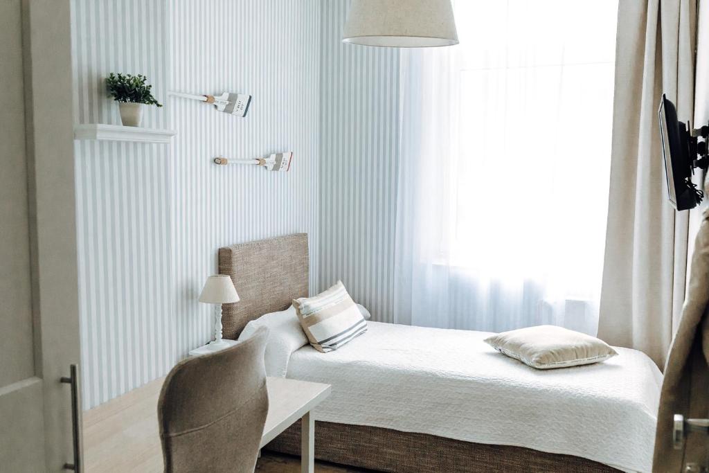 een slaapkamer met een bed, een stoel en een raam bij Apartment an der Altstadt (#8) in Hameln