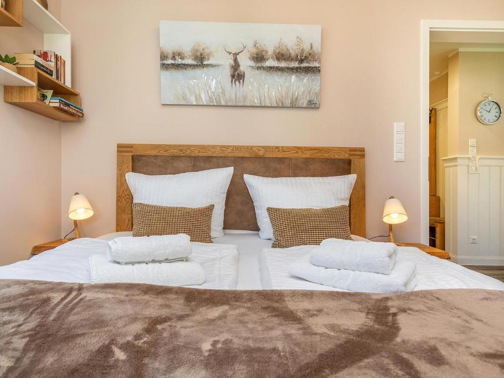 una camera da letto con un grande letto con due cuscini bianchi di Haus Ostseewind - Strandwiese Zingst Suite Windböe - Ferienanlage Strandwiese a Zingst