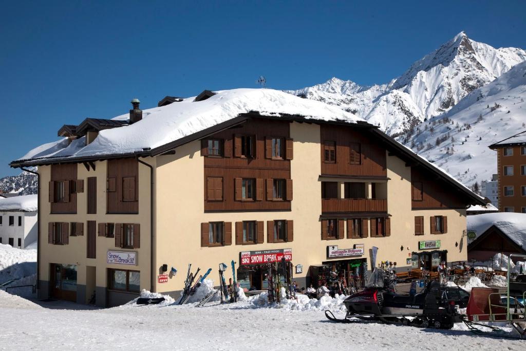 a large building with snow on top of it at Residence Redivalle in Passo del Tonale