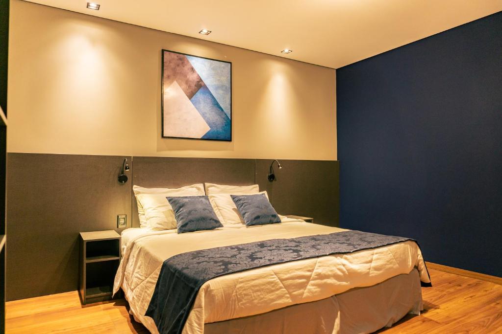 sypialnia z łóżkiem i obrazem na ścianie w obiekcie Mayná Hotel Prudentópolis Centro w mieście Prudentópolis