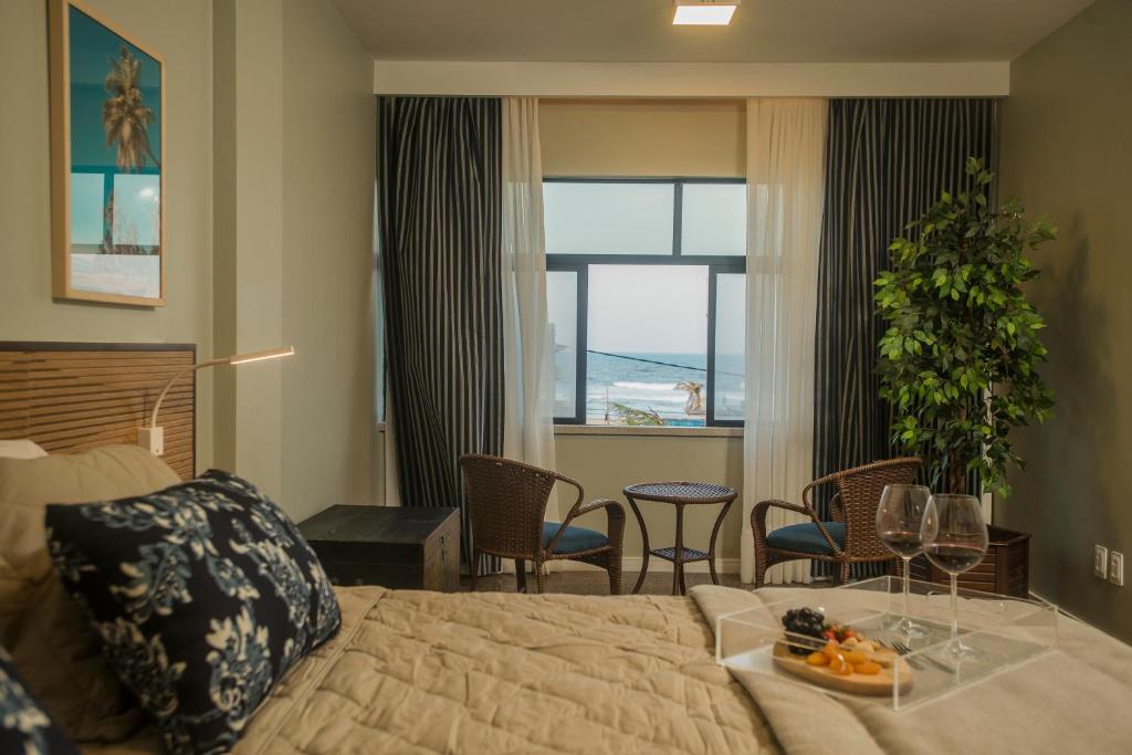 a bedroom with a bed and a table with a tray of food on it at Janela de Sol in Fortaleza