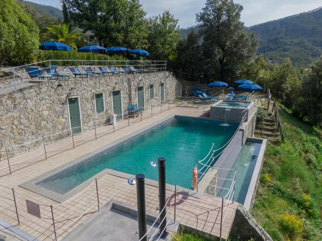 une grande piscine avec des parasols bleus dans l'établissement Hotel Al Terra Di Mare, à Levanto