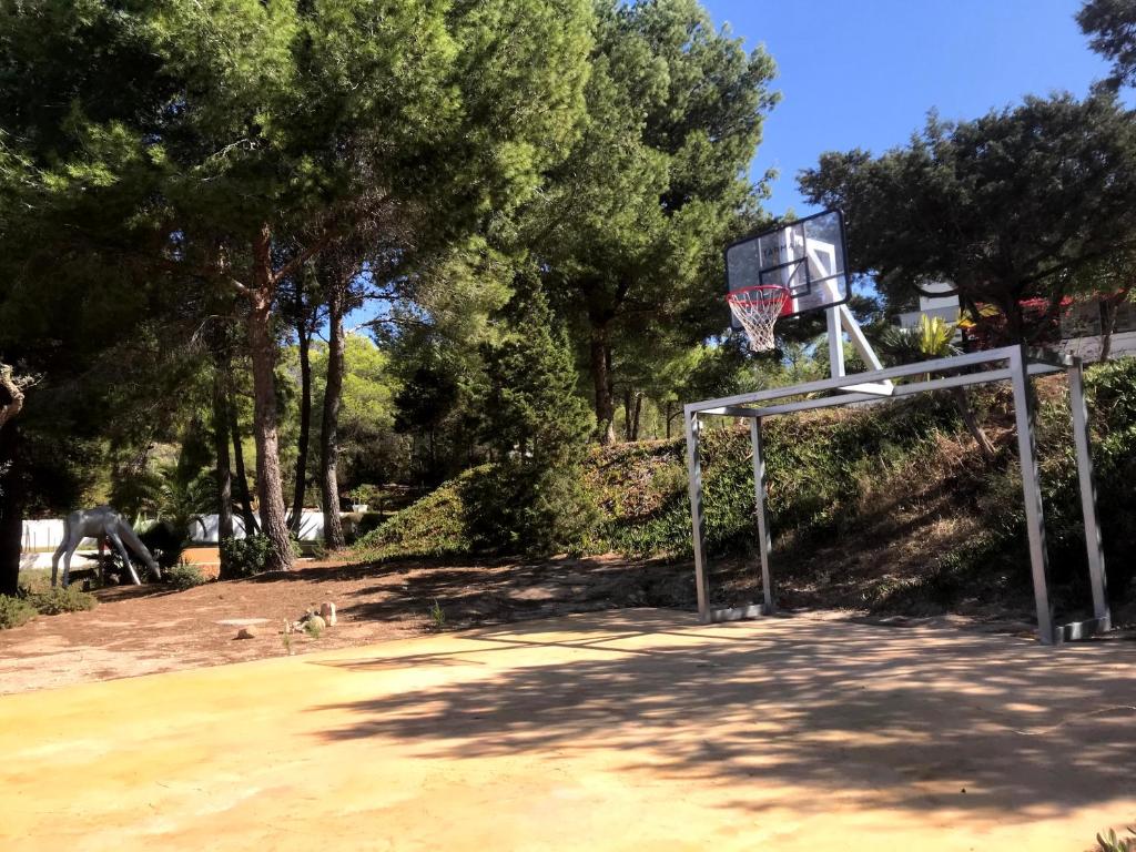 a basketball hoop in a park with trees at Nyumba ya Sun in Cala Tarida