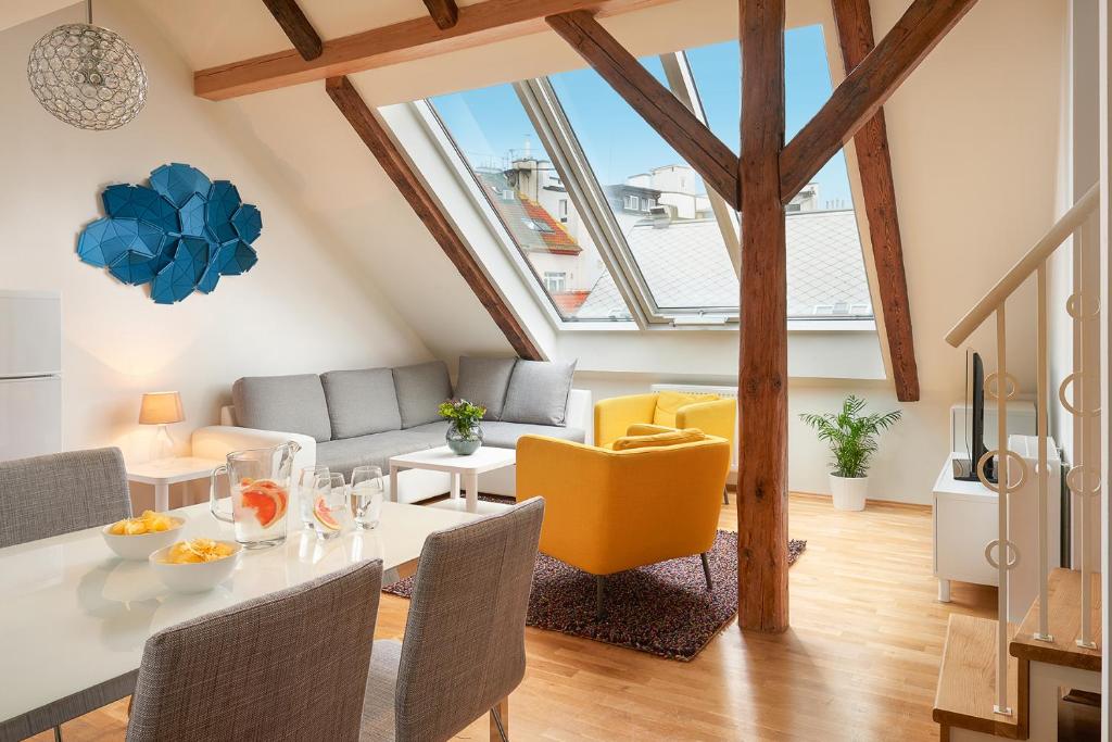 a living room with a table and yellow chairs at Residence Vocelova in Prague