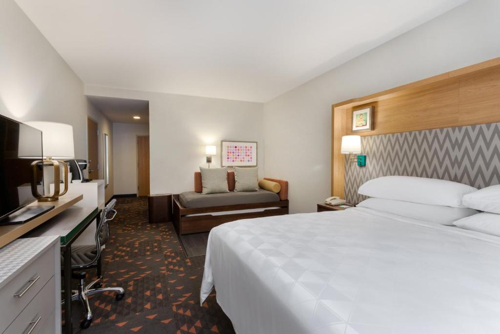 a hotel room with a large bed and a couch at Holiday Inn Winter Haven by IHG in Winter Haven