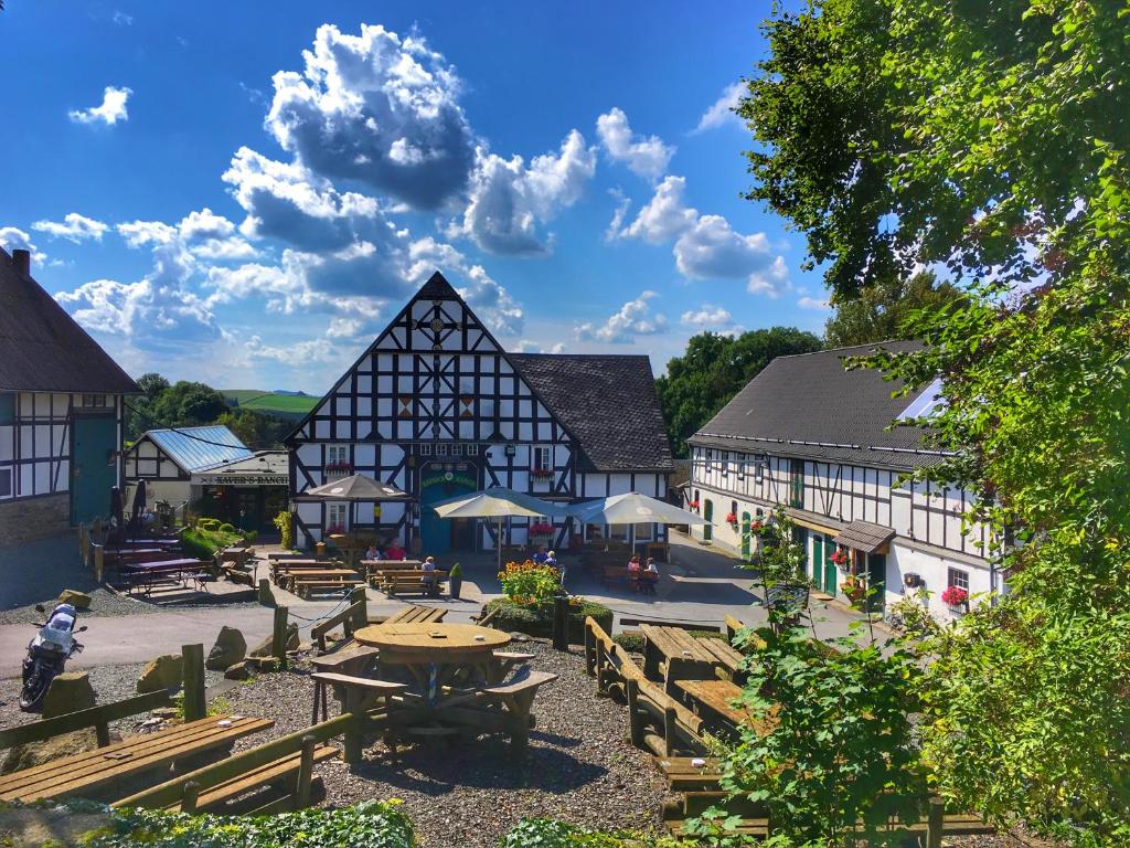 een groep gebouwen met een picknicktafel en banken bij Xavers Ranch in Meschede