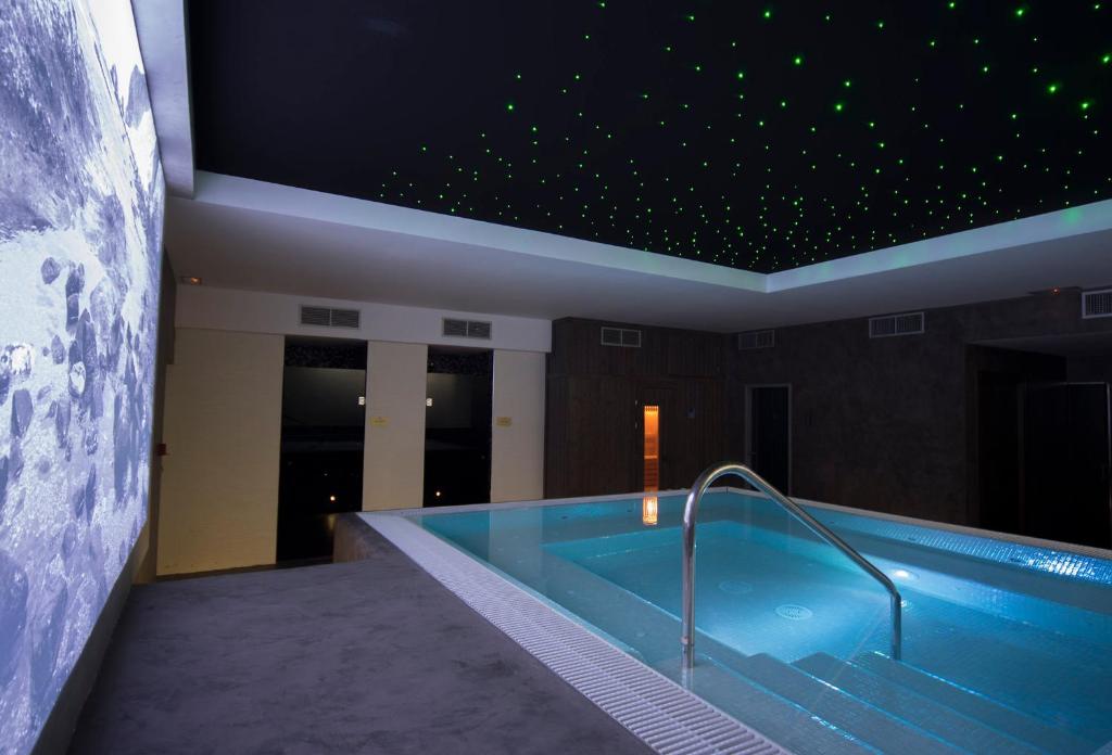 a swimming pool in a building with a star ceiling at Hotel La Posada De Paco - Spa & Adults Friendly in San José