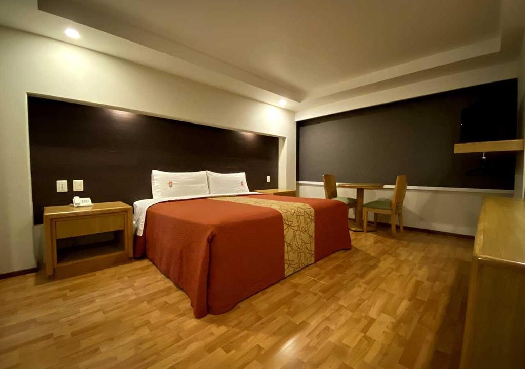 a bedroom with a bed and a table and a chalkboard at Hotel Lord in Mexico City