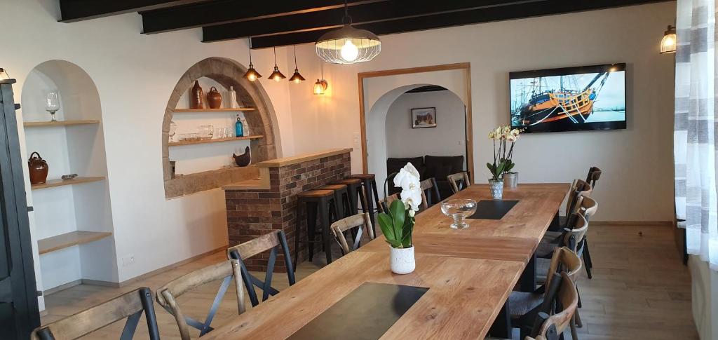 une salle à manger avec une grande table et des chaises en bois dans l'établissement Sur La Route Des Myrtilles, à Gouézec