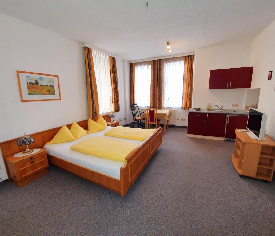 a bedroom with a large bed and a kitchen at Appartement zur Post in Ferlach