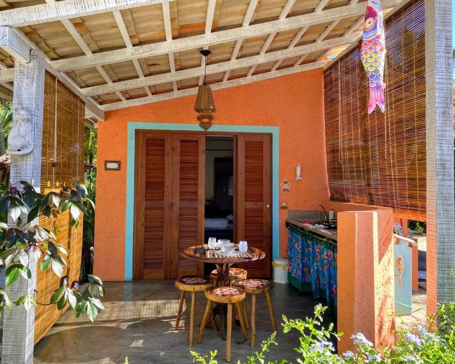 Un patio con mesa y sillas y una cocina. en CasAmar Pé na Areia em Condomínio Beira Mar, en Serra Grande