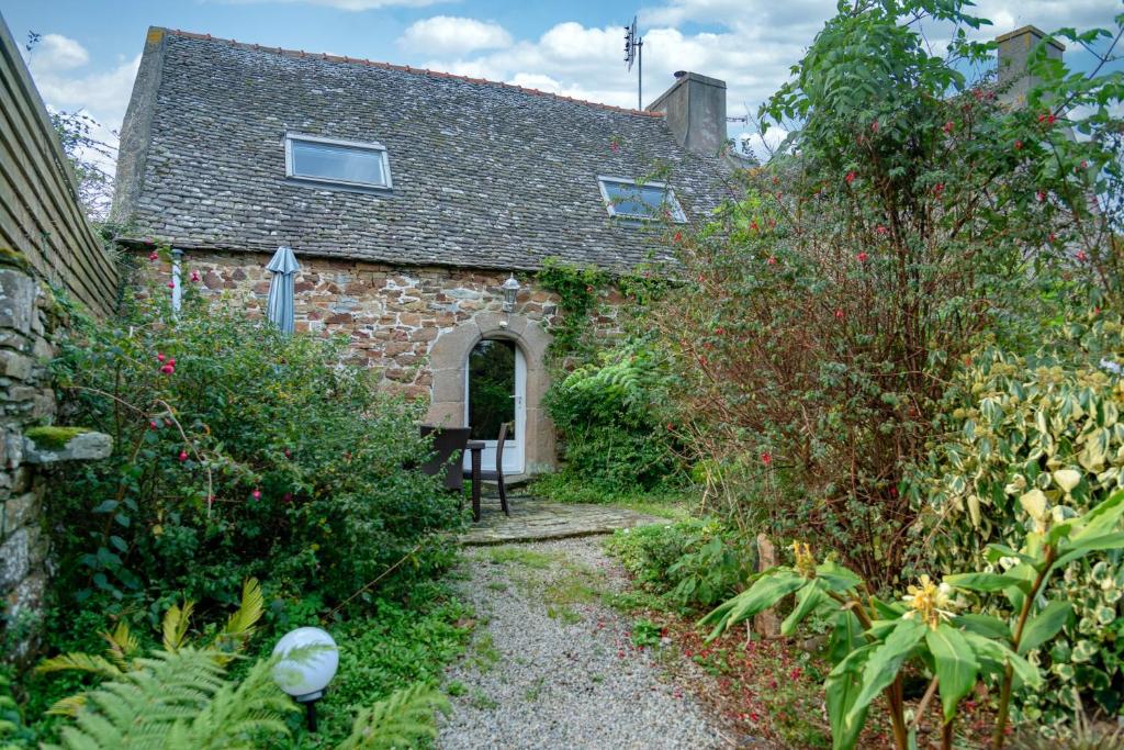 ein altes Steinhaus mit Garten davor in der Unterkunft Maison de 2 chambres a Guimaec a 500 m de la plage avec vue sur la mer jardin amenage et wifi in Guimaëc