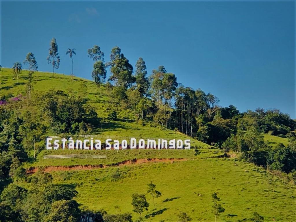 a green hill with a sign on top of it at Pousada Campestre Estância São Domingos in Serra Negra