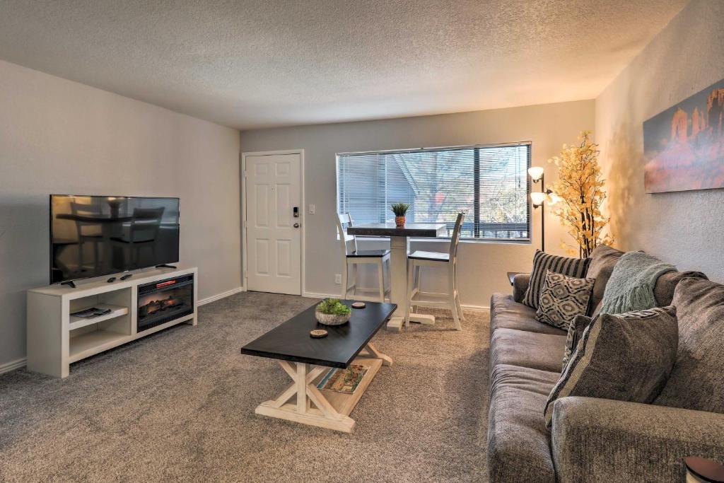 a living room with a couch and a tv and a table at Sedona Escape Walk to Dining, 7 Mi to Uptown! in Sedona