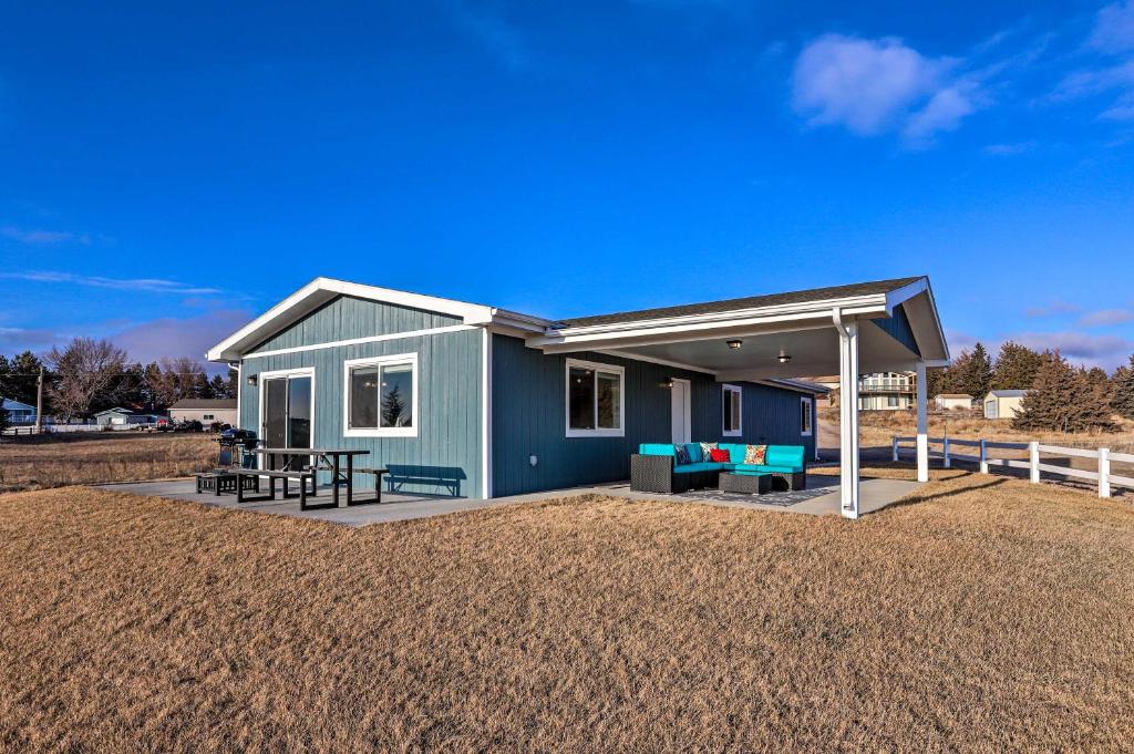 a small blue house with a roof on a yard at Lake McConaughy Getaway with Covered Patio in Belmar