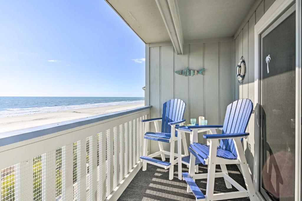 On-The-Beach Escape Oceanfront in Surfside! في ميرتل بيتش: كرسيين وطاولة على شرفة مع الشاطئ