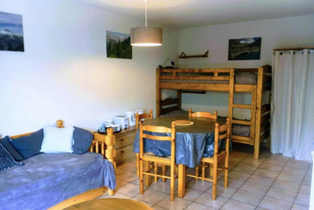 een slaapkamer met een bed, een tafel en een stapelbed bij Family Flat Cosy 35m Terrace 10m For 6 Pers in La Salle Les Alpes