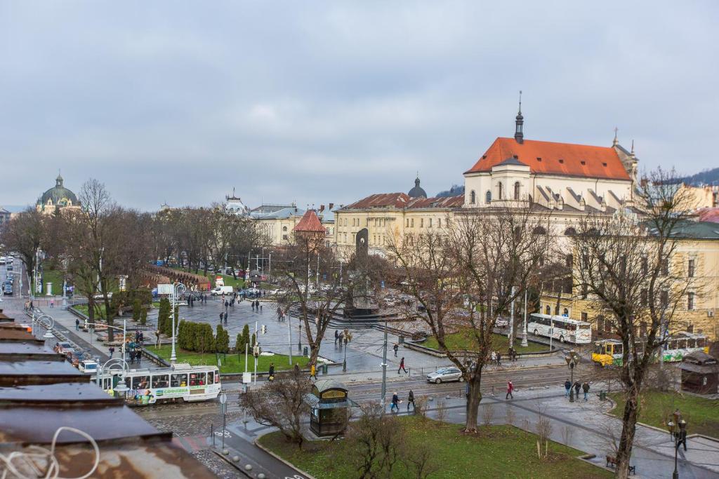 une ville avec des bâtiments et une rue avec des bus dans l'établissement В центрі біля Ратуші вулиця Площа Ринок 11, à Lviv