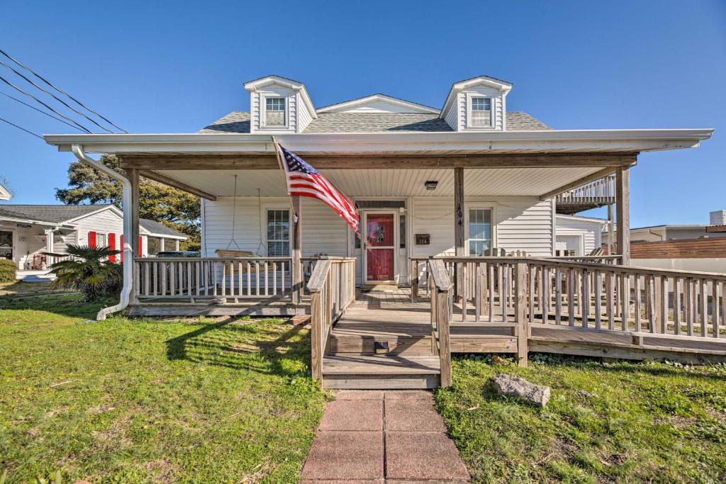 une maison avec une terrasse couverte arborant un drapeau américain. dans l'établissement Charming Retreat with Water View, Walk to Downtown, à Beaufort