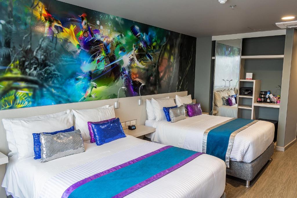 two beds in a room with a painting on the wall at Hotel Black Tower Premium in Bogotá