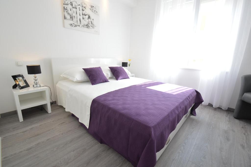 1 dormitorio con 1 cama grande con manta morada en Downtown Main Street Studio, en Zadar