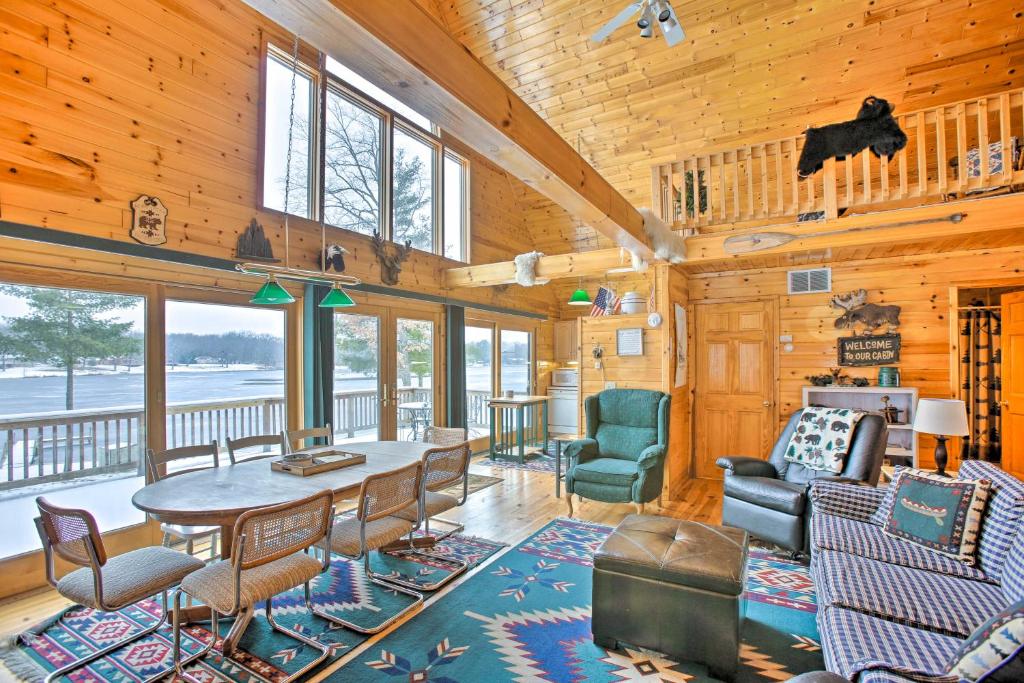 a living room with a table and chairs at Peaceful Long Lake Cottage with Deck, Dock and Kayaks! in Branch Township