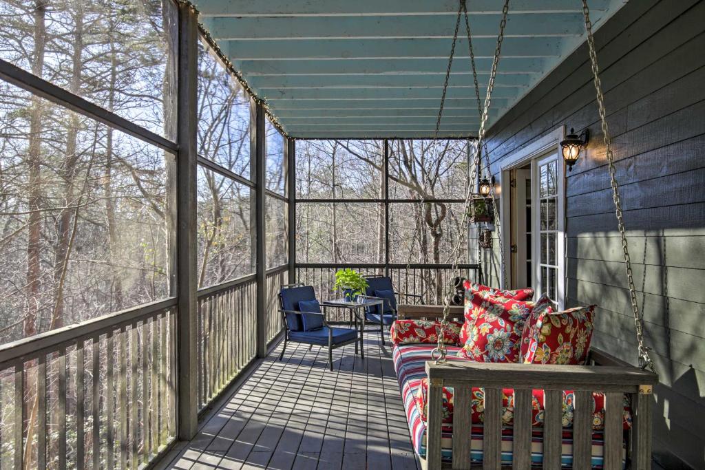 a screened porch with a swing and a table and chairs at Cozy and Quiet Studio with Porch, Near Scenic Railway! in Blue Ridge