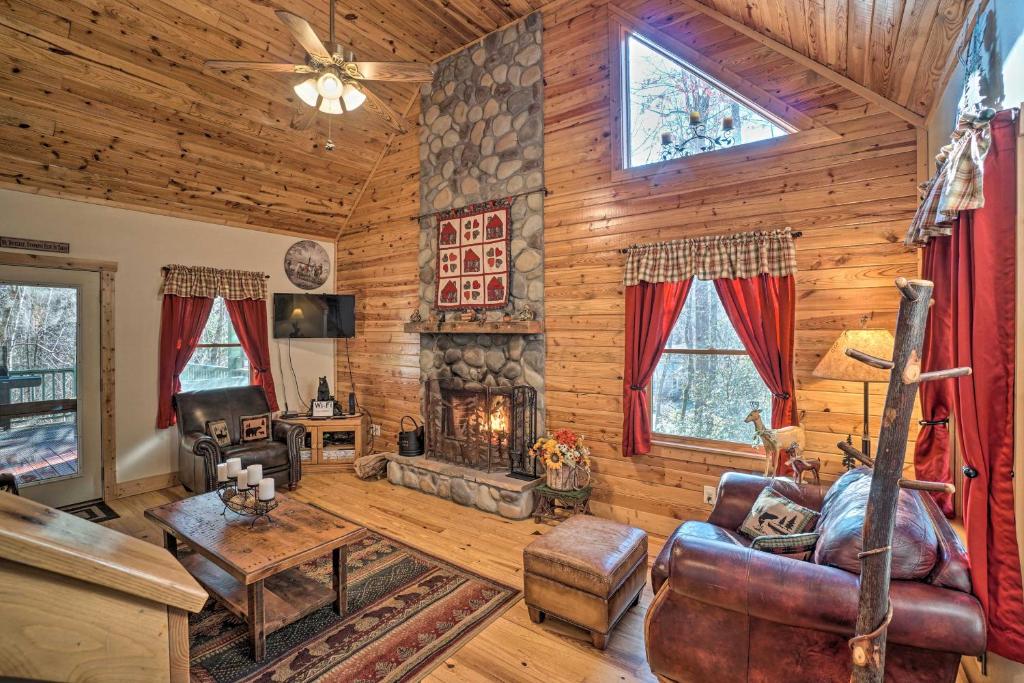 a living room with a fireplace in a log cabin at Outdoor Adventure - Charming Cabin with Hot Tub in Sautee Nacoochee