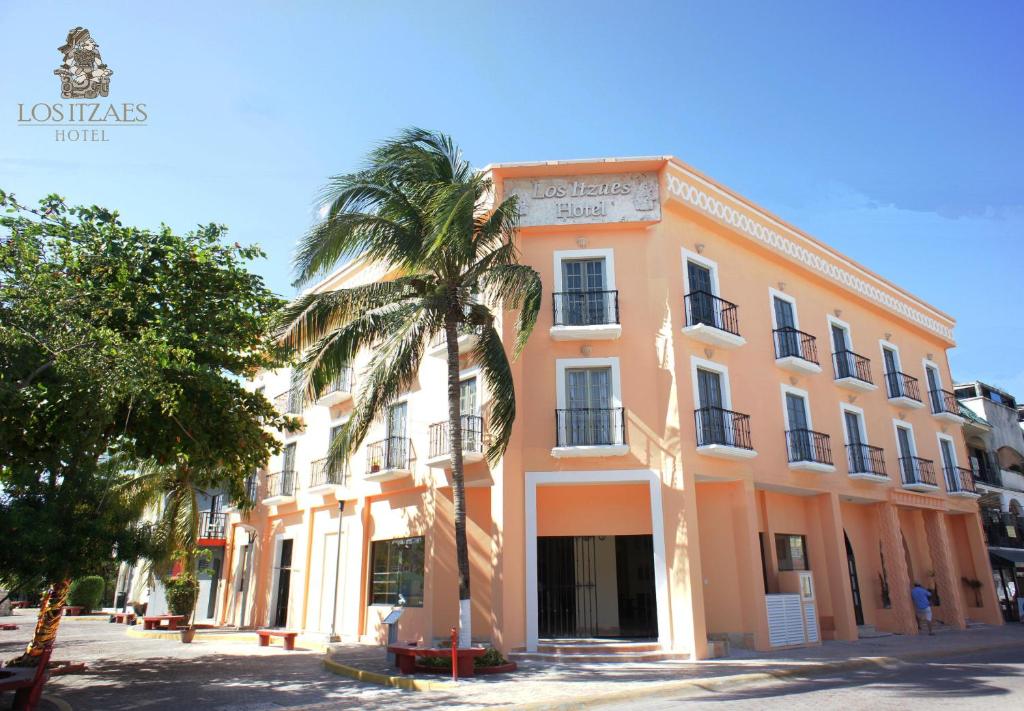 a palm tree in front of a building at Hotel Los Itzaes by 5th av in Playa del Carmen